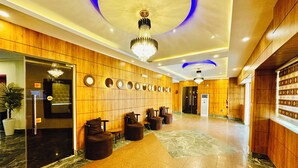 A hotel lobby with a marble floor, wooden paneling, a chandelier, and a reception desk. - Presken Awolowo Way - Ikeja (Lagos)