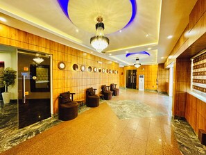 A hotel lobby with a marble floor, wooden paneling, a chandelier, and a reception desk. - Presken Awolowo Way - Ikeja (Lagos)