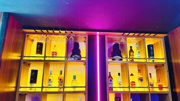 Um balcão de bar com várias prateleiras cheias de garrafas de bebidas e copos.