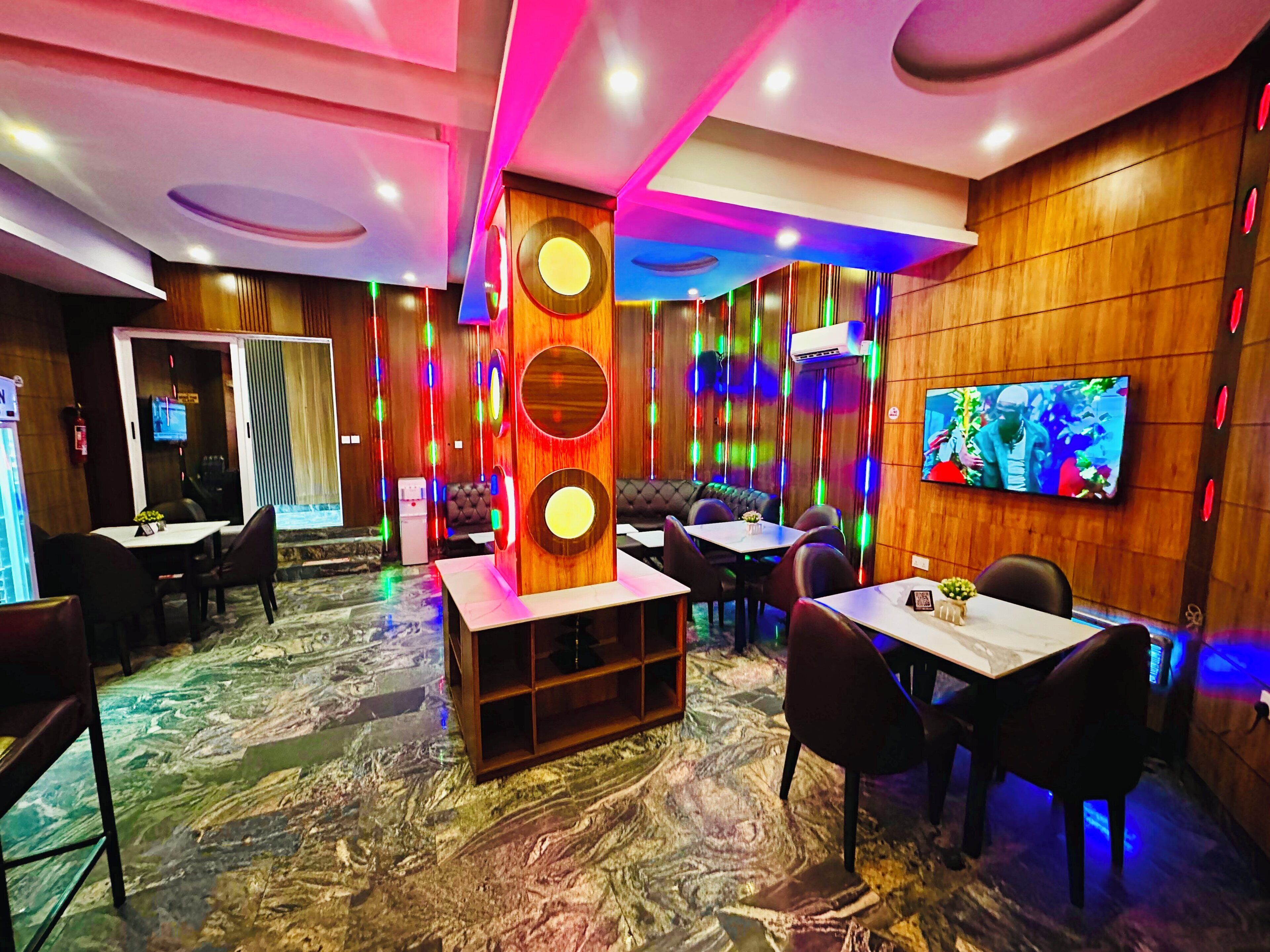 A modern interior with a central column, seating arrangements, and a television on the wall.