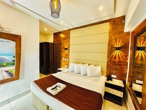 A modern hotel room with a large bed, a wooden wardrobe, a wall-mounted TV, and a ceiling light fixture. - Presken Awolowo Way - Ikeja (Lagos)