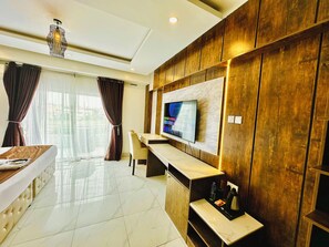 A modern hotel room with a flat-screen TV mounted on a wooden panel wall, a comfortable bed with a headboard, a small desk with a chair, and a large window with curtains. - Presken Awolowo Way - Ikeja (Lagos)