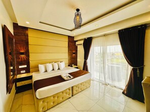 A modern hotel room with a large bed, a bedside table, a window with curtains, and a ceiling light fixture. - Presken Awolowo Way - Ikeja (Lagos)
