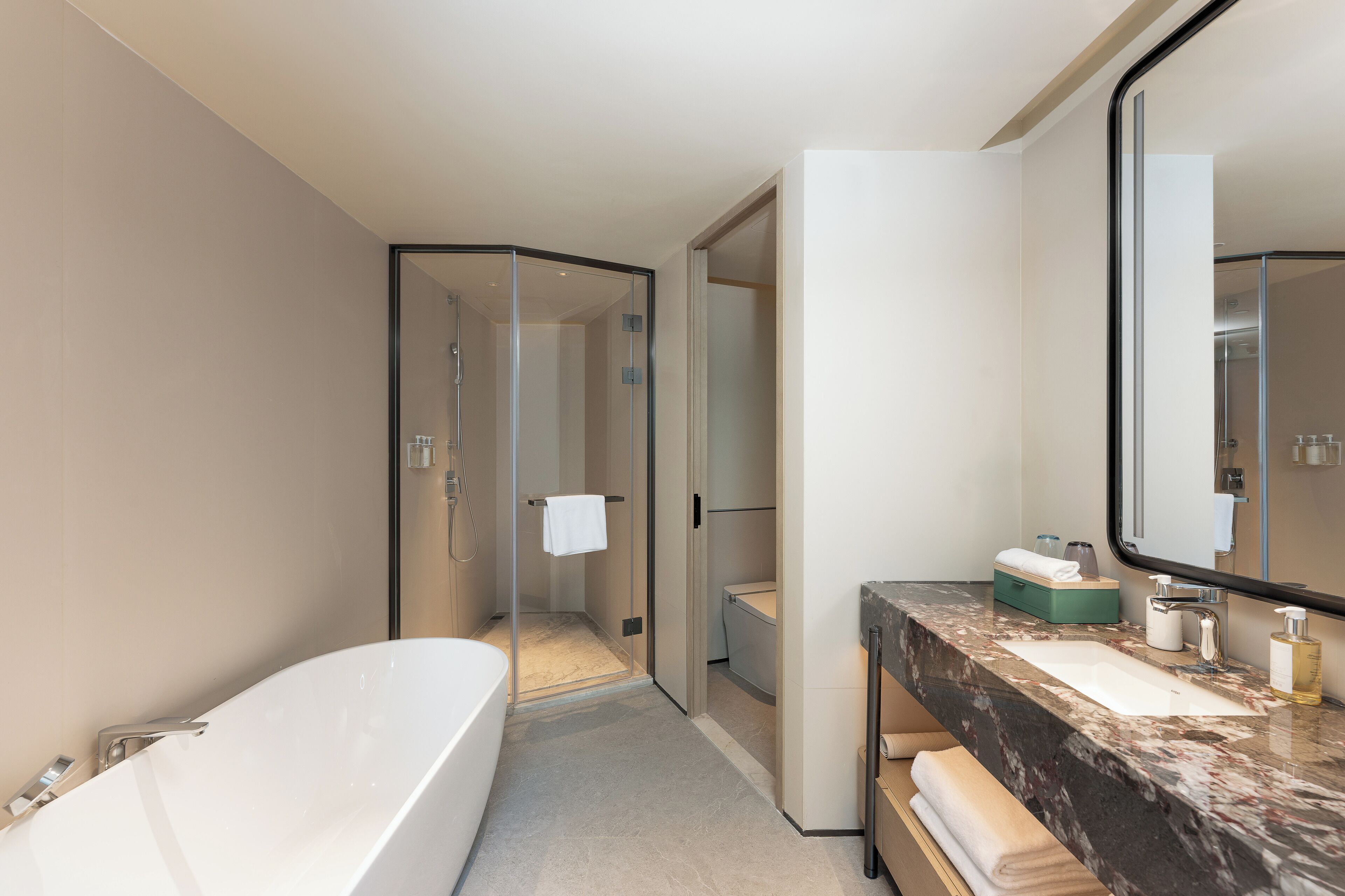 A modern bathroom with a bathtub, a sink, and a glass-enclosed shower.