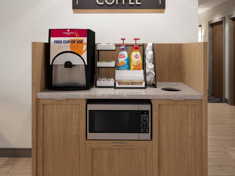 Un espace dédié au café, avec une pancarte indiquant « CANDLEWOOD COFFEE » et une machine à café.