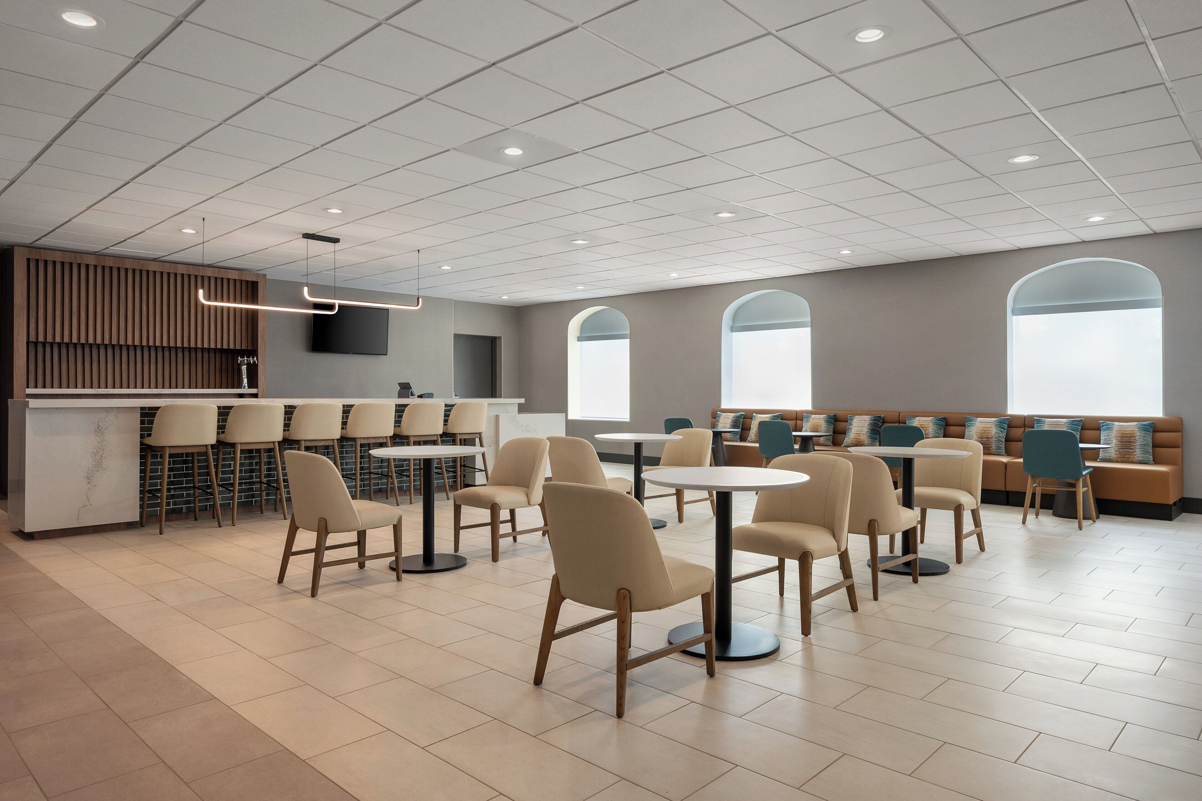 Een modern interieur met een receptiebalie, een zithoek en grote ramen.
