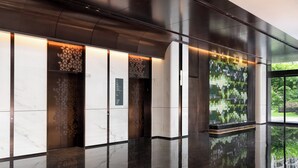 A modern elevator interior with a marble finish, geometric wall patterns, and a digital display. - Holiday Inn Hotel & Suites Shanghai Changfeng by IHG (Shanghai)