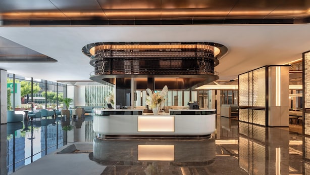 A modern lobby with a central reception desk, a glass pool, and a view of the outdoors. - Holiday Inn Hotel & Suites Shanghai Changfeng by IHG (Shanghai)