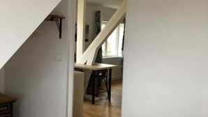 Une chambre à coucher avec un lit, une serviette jaune et un couvre-lit blanc.