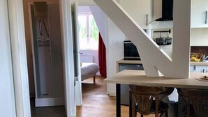 Une cuisine moderne dotée d’un îlot central, de planchers en bois et d’un escalier menant à un autre niveau.