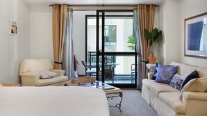 A hotel room with a bed, two armchairs, a coffee table, and a balcony with a view of the city. - Central City Winter Escape HotTub HeatedPool Sauna (Auckland)