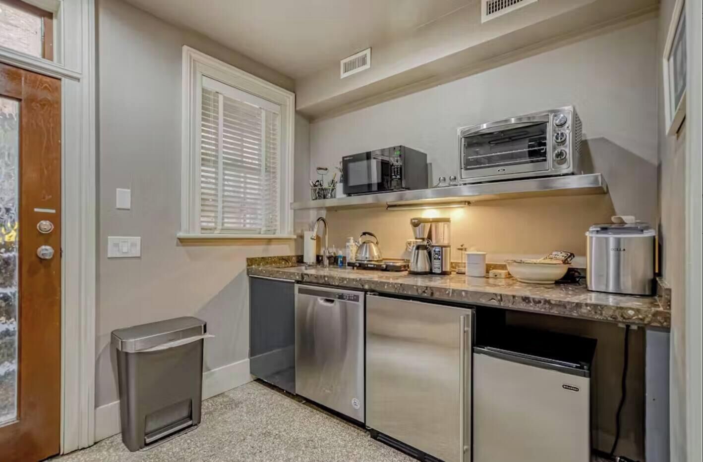 A compact kitchen with a dishwasher, a microwave, and a coffee maker.