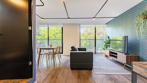 A modern living room with a sofa, TV, and dining area. - VH | Condesa | Natural Light + Balcony & Gym | 250 (Ciudad de México)