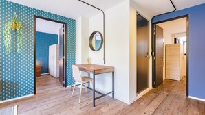 A modern room with a wooden floor, a dining table with a chair, a hanging plant, and a mirror on the wall. - VH | Condesa | Natural Light + Balcony & Gym | 250 (Ciudad de México)