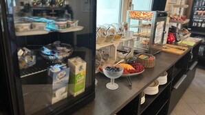 Ein Frühstücksbuffet mit verschiedenen Speisen und Behältern.