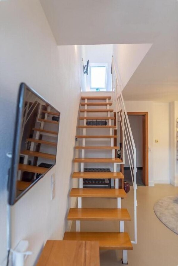 A staircase with wooden steps and white railings, leading to a landing with a small window. - PRINCESS No.3 in Plochingen bei Stuttgart (Plochingen)