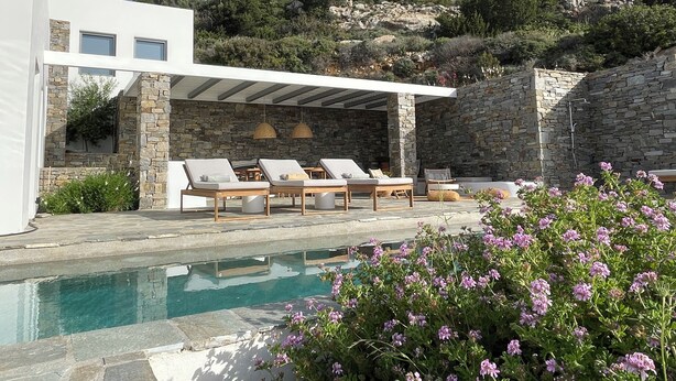 A modern outdoor pool area with lounge chairs and a pergola.