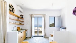 A modern hotel room with a kitchen, a bathroom, and a balcony with a view.