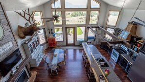 A spacious kitchen with a dining area, large windows, and a mounted deer head. - Breathtakingly charming 4-bedroom house with WiFi in Charlo. (Charlo)