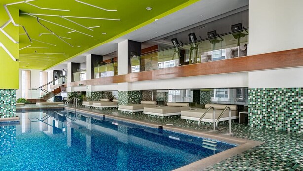 A swimming pool with a tiled floor and a glass railing. - Sleek High-Rise with Pool, Gym, Jacuzzi & BBQ Area (Mexico City)