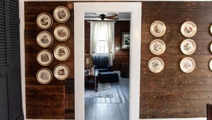A room with wooden walls and a ceiling fan, featuring a sofa and a coffee table in the center. - Little Noone by Raven’s Keep (Jackson)