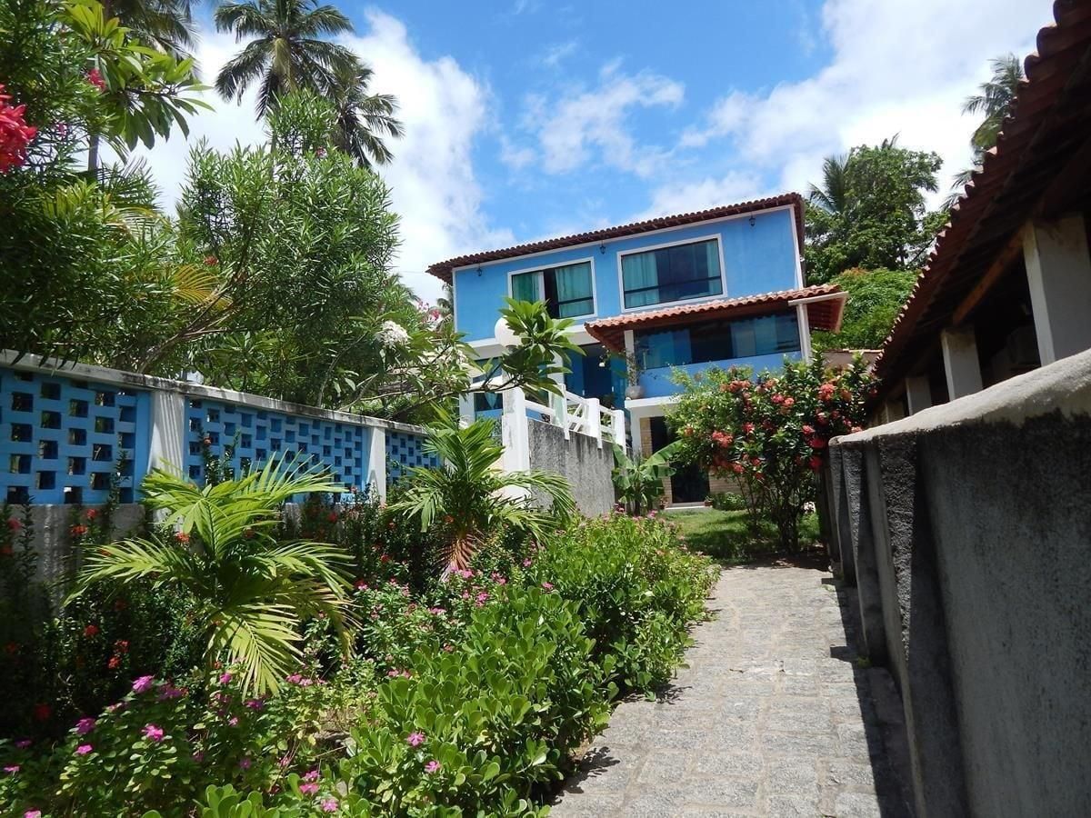 A pathway leading to a building with a blue facade and a tiled roof.