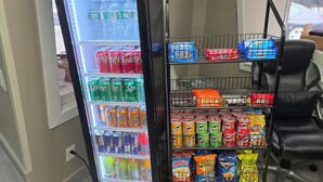 Ein Getränkeautomat mit verschiedenen Getränken und Snacks, darunter Limonade, Energydrinks und Chips.