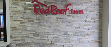 A RedRoof Inn sign on a stone wall.
