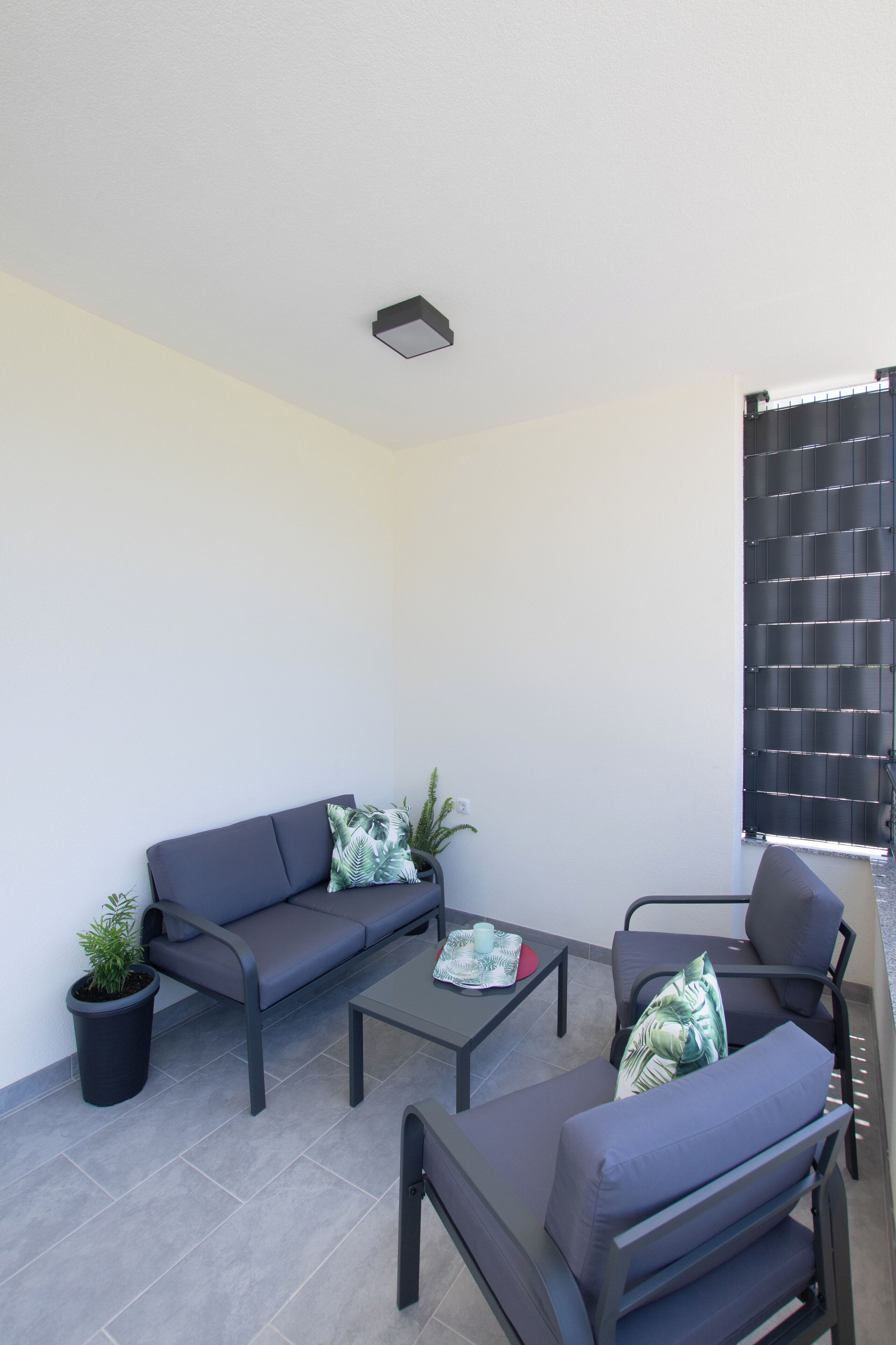 A modern outdoor seating area with a sofa, chairs, and a coffee table.
