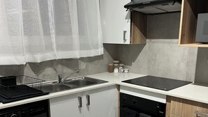 Une cuisine moderne équipée d’un lave-vaisselle, d’un lave-linge, d’une cuisinière, d’un four et d’un four à micro-ondes.