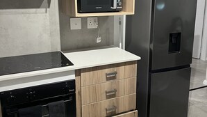 Une cuisine équipée d’un four à micro-ondes, d’un four et d’un réfrigérateur intégrés.