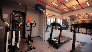 Ein Fitnessstudio mit Laufbändern, Ergometer und Rudergerät.