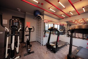Ein Fitnessstudio mit Laufbändern, Ergometer und Rudergerät.