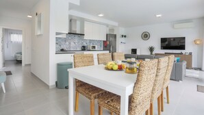 A modern kitchen with white cabinets, a grey tiled backsplash, and a built-in oven.