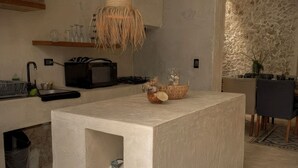A modern kitchen with a central island, hanging light fixtures, and patterned floor tiles. - Ek Balam House - Merida Downtown (Centro)