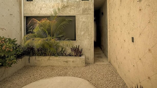 A modern building with a concrete facade, two large windows, and a small entrance. - Ek Balam House - Merida Downtown (Centro)