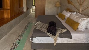 A bedroom with a large bed, a ceiling fan, a TV, and a wooden floor. - Ek Balam House - Merida Downtown (Centro)
