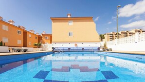 A swimming pool with a tiled pattern, surrounded by buildings with balconies and a clear sky. - Home2Book Rotia Duplex Caletillas, Terrace (Las Caletillas)