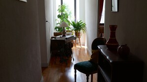 A hallway with wooden flooring, a dining area with a table and chairs, a potted plant, and a lamp. - Country house 8 persons - Dogs allowed (Valdoule)