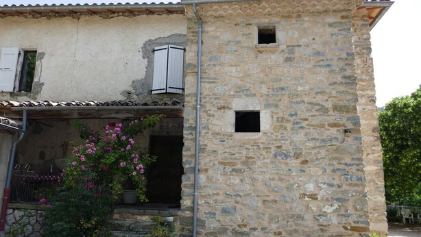 A stone building with a rustic exterior, a small entrance, and a flower box with pink flowers. - Country house 8 persons - Dogs allowed (Valdoule)