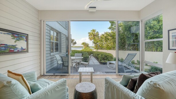 A sunlit patio with a view of the water, a dining table, and a sofa. - Waterfront, Spa/Pool, Private Paradise on Longboat Key! (Longboat Key)