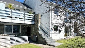 A modern house with a stone staircase leading to a balcony. - Ty Golau (Pwllheli)