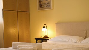 A neatly made bed with white linens and towels, a bedside lamp, and a wooden wardrobe. - Grigna Mountain View (Narro-indovero)