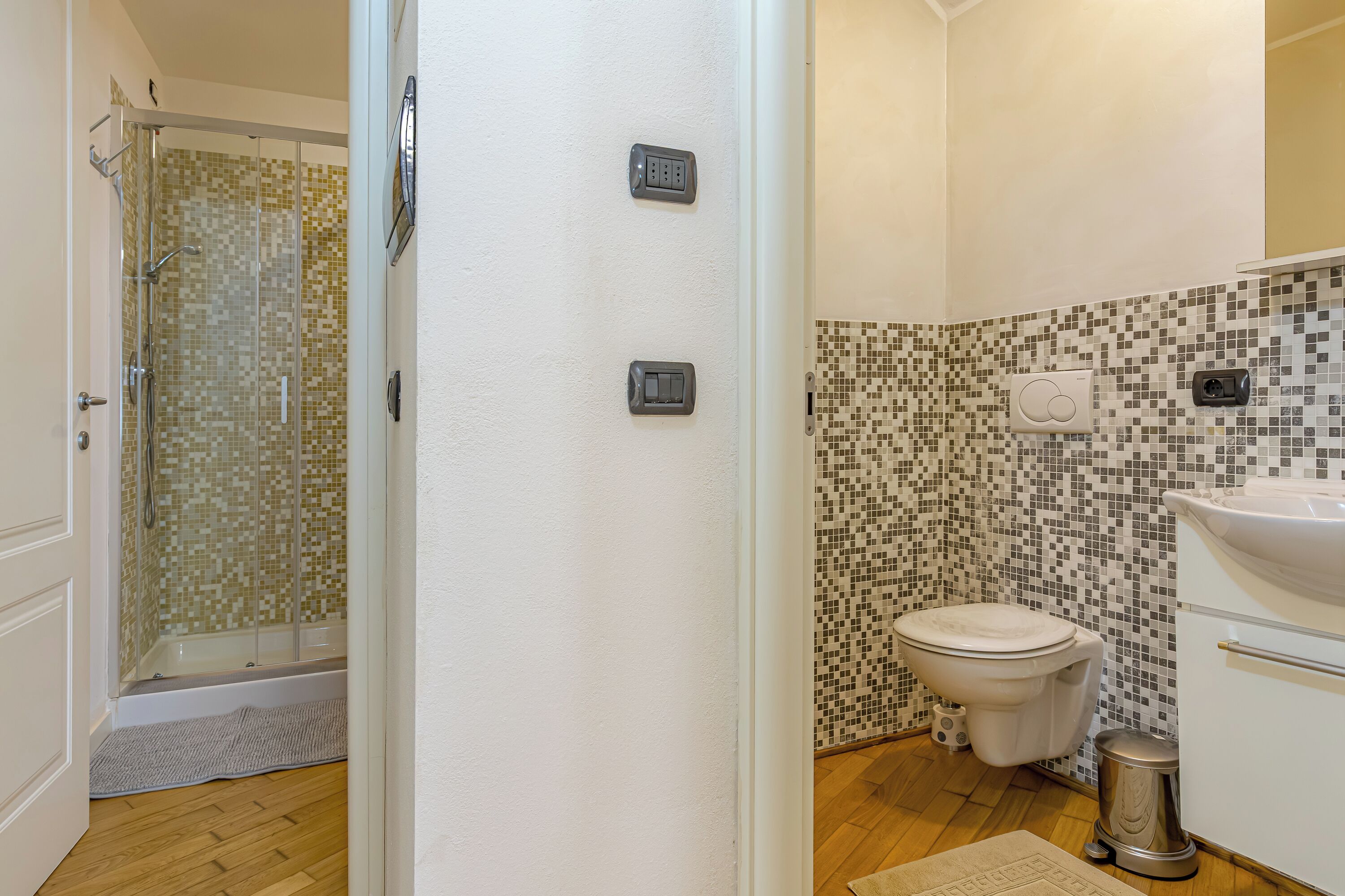 A bathroom with a shower, toilet, and sink.