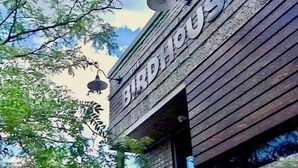 A building with a wooden facade and the sign "Birdhouse" visible.