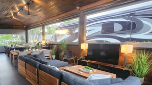 A modern outdoor seating area with wooden furniture, a flat-screen TV, and ambient lighting. - The duo of a prestigious holiday home and the comfort of a luxurious Motor Coach (Margate)