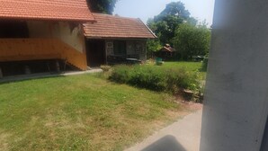 A house with a red-tiled roof, a small porch, and a grassy yard. - Viva Ve (Brinje)