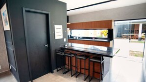 Una cucina moderna con una porta scura, mobili in legno e un angolo bar con sgabelli.