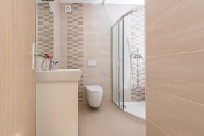 A modern bathroom with a glass shower enclosure, a toilet, and a sink with a mirror. - Luxury Escape With Swimming Pool & Modern Design (Sukosan)