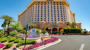 A large, multi-story hotel with a prominent sign indicating it is Wyndham Grand Desert 265. - Cozy 1BD Suite in fabulous Las Vegas near the Strip! (Las Vegas)